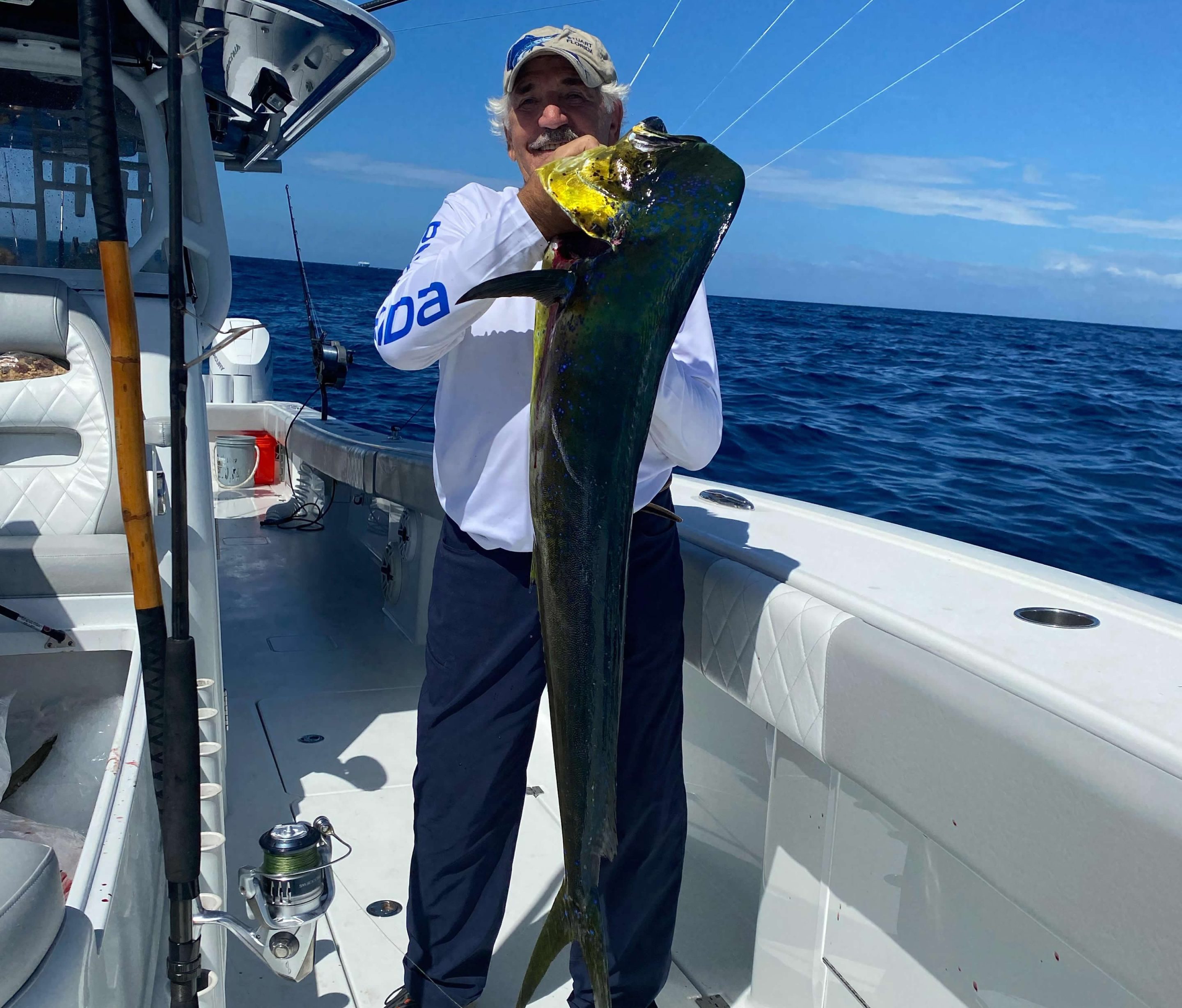 Fisherman holding mahi-mahi on Next Level fishing boat